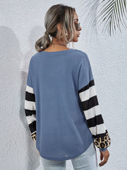 Sky blue waffle knit top with striped and leopard print sleeves.