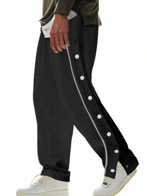 Black men's track pants with side snap buttons and reflective stripe detail.