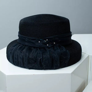 Black wheat straw cloche hat with ribbon and jeweled embellishments