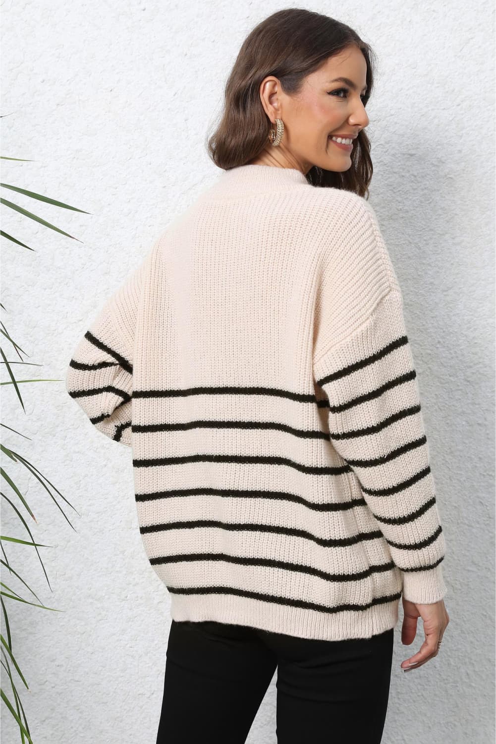 Beige ribbed knit sweater with black horizontal stripes and a quarter-zip neckline.