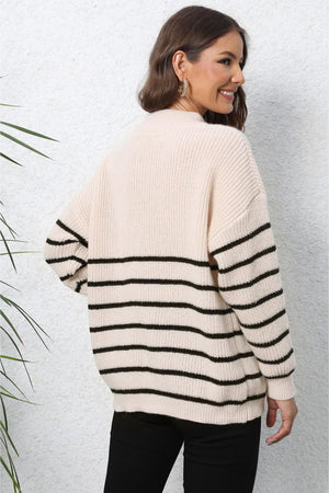 Beige ribbed knit sweater with black horizontal stripes and a quarter-zip neckline.