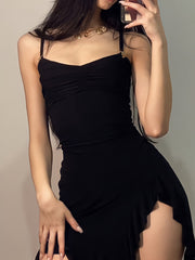 Black asymmetrical ruched mini dress with a high slit and gold hardware detail on straps.
