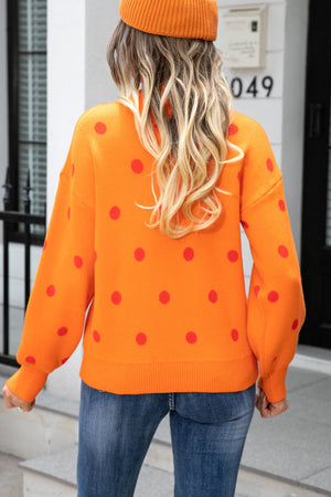 Orange polka dot knit sweater with balloon sleeves and a ribbed hem.