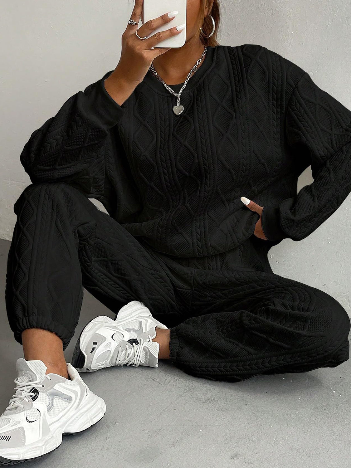 Black cable knit loungewear set with crew neck sweatshirt and cuffed joggers.