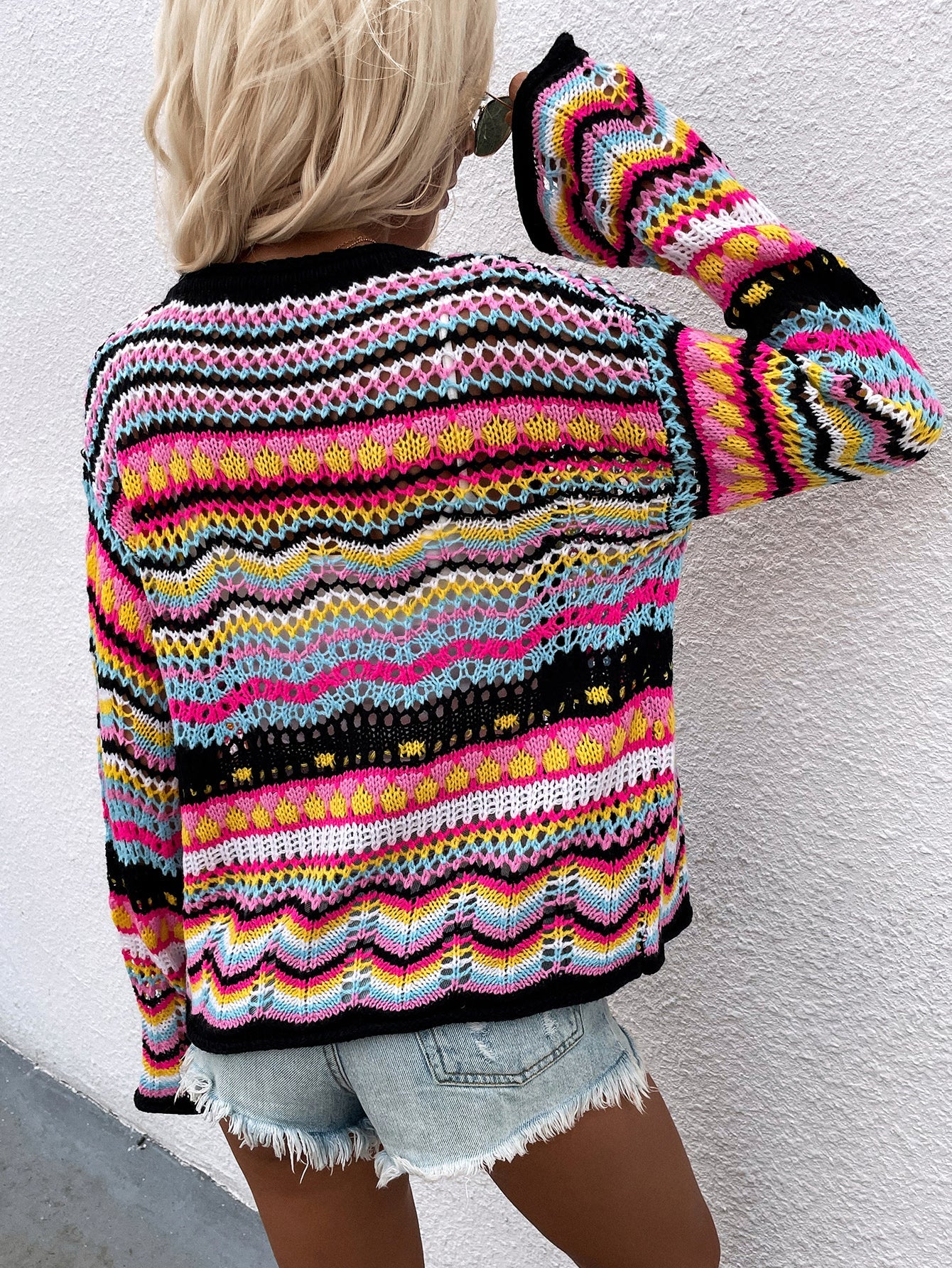 Rainbow chevron knit cardigan with open weave and bell sleeves.