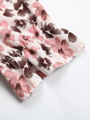 Floral tie-neck ruffle shirt with pink and brown blooms and ruffled sleeves.