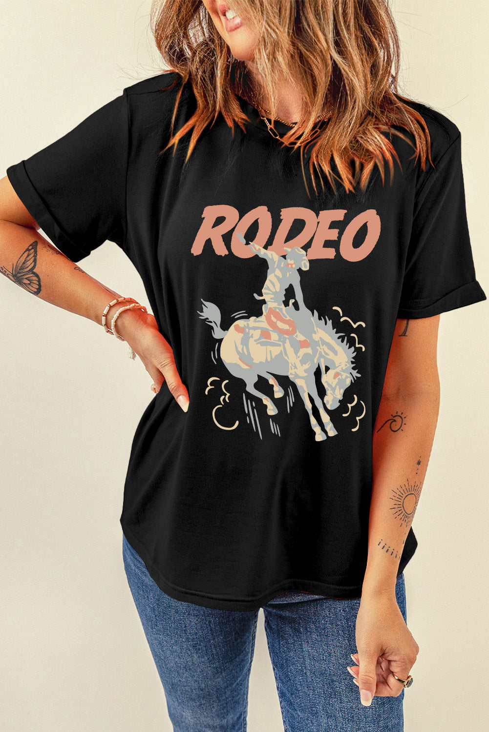 Black rodeo graphic tee with rolled sleeves and a distressed cowboy on a bucking horse design.