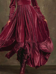Elegant cerise velvet maxi dress with voluminous sleeves and ruffled hem.