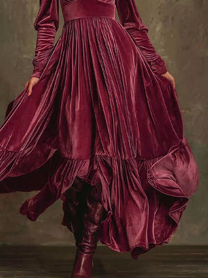 Elegant cerise velvet maxi dress with voluminous sleeves and ruffled hem.