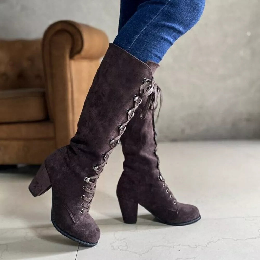 Brown suede lace-up block heel boots with decorative lacing detail.