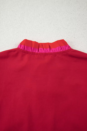 Ruffled maternity blouse in red with pink and red striped ruffle collar detail.