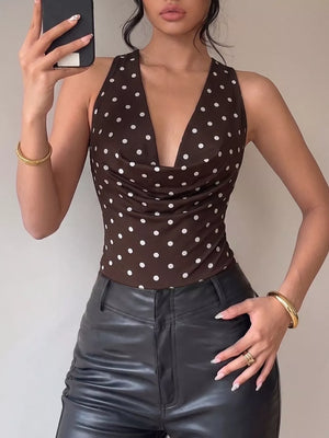 Brown polka dot bodysuit with cowl neck and halter straps, paired with black leather pants.