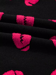 Black knit sweater with pink broken heart pattern
