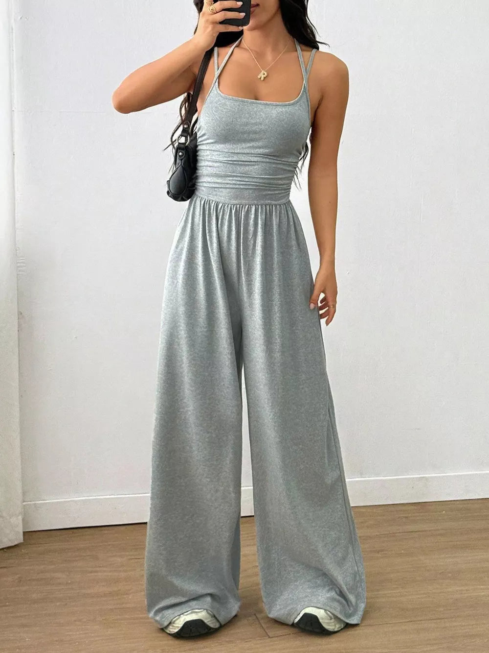 Light gray ruched wide-leg jumpsuit with spaghetti straps and a square neckline.