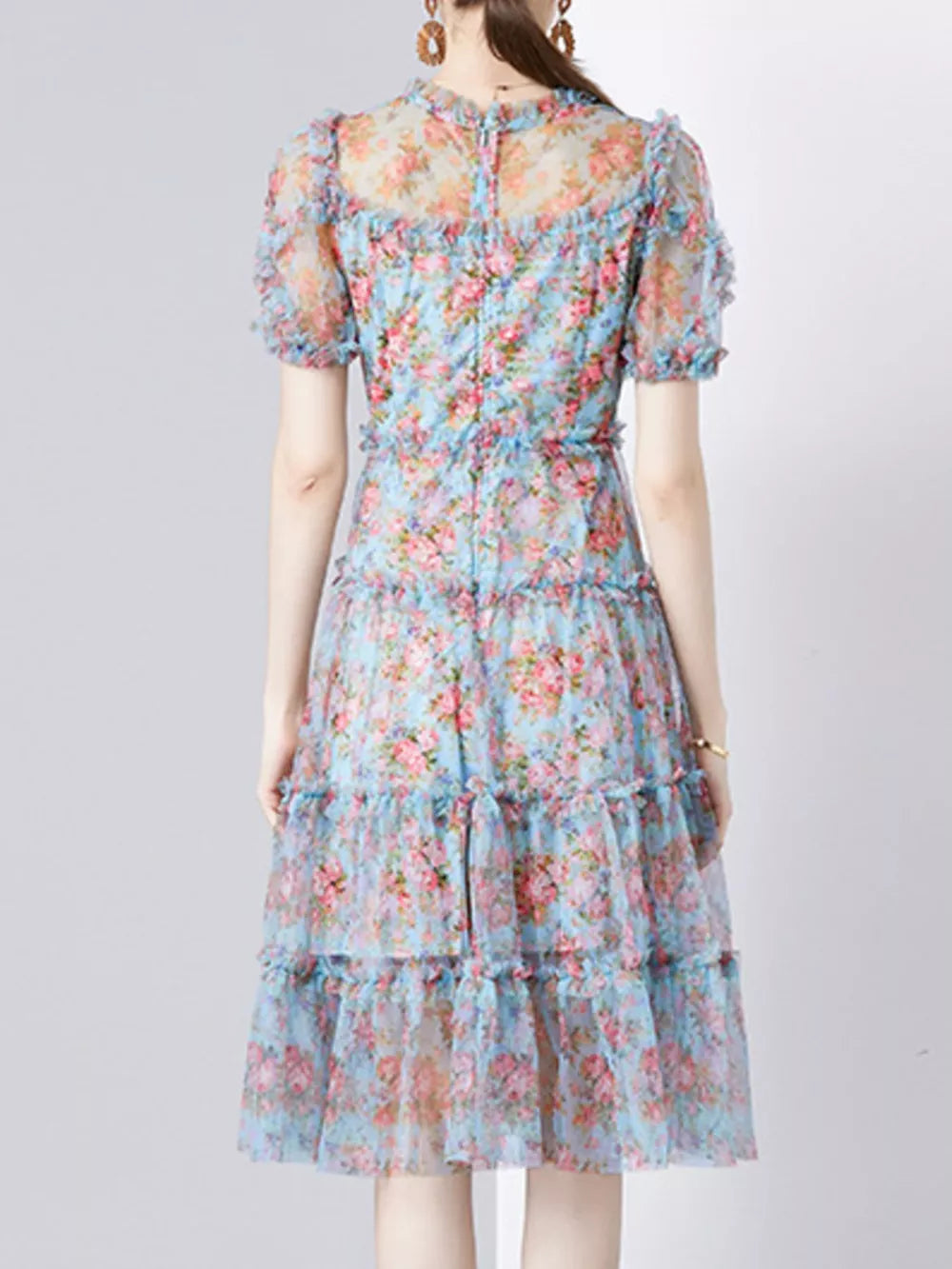 Ruffled floral dress with sheer sleeves and tiered skirt.