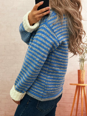 Blue and gray striped knit cardigan with textured white cuffs.