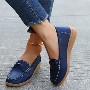 Dark blue leather loafers with braided detail and white stitching.