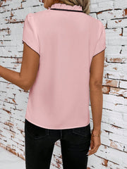 Pink maternity blouse with ruffled tie-neck and black trim, short sleeves.