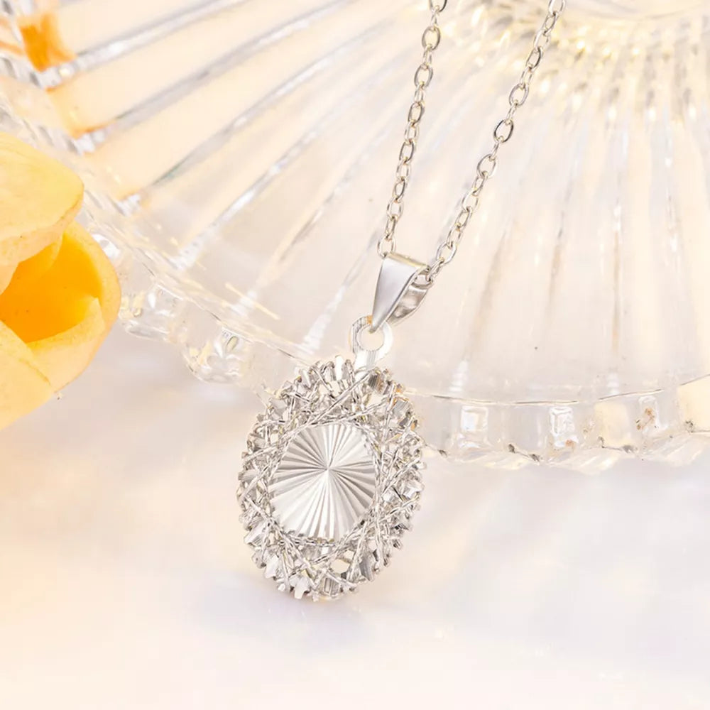 Silver openwork pendant necklace with delicate chain and oval cage design.