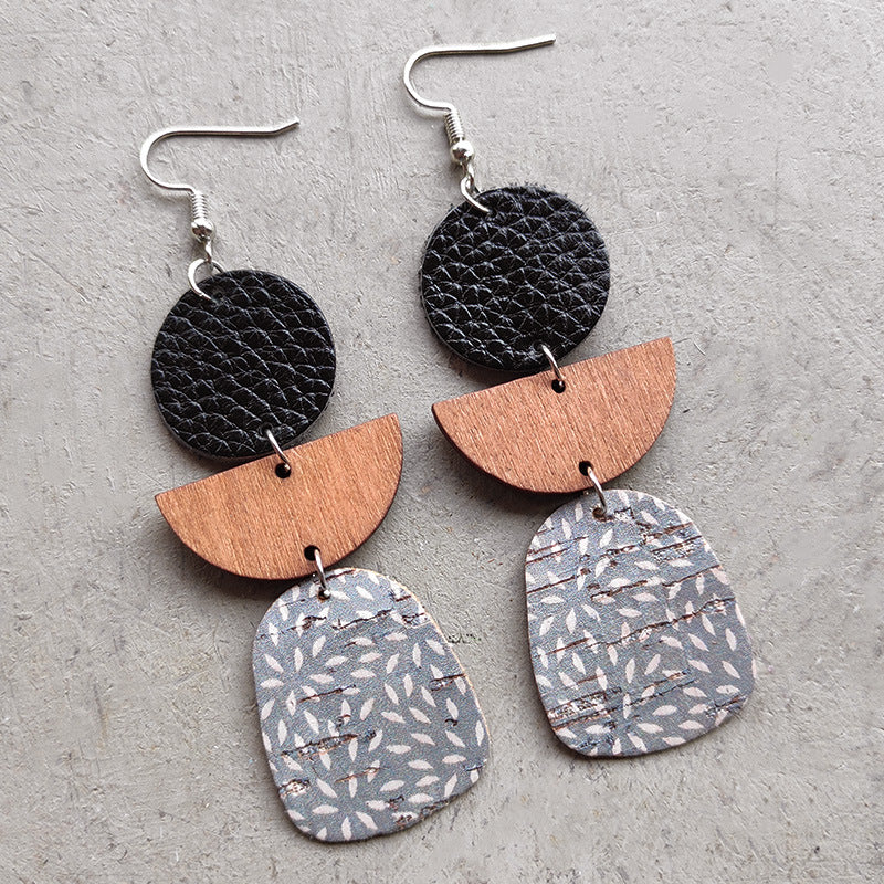 Geometric layered leather & wood earrings with black, wood, and patterned gray elements.