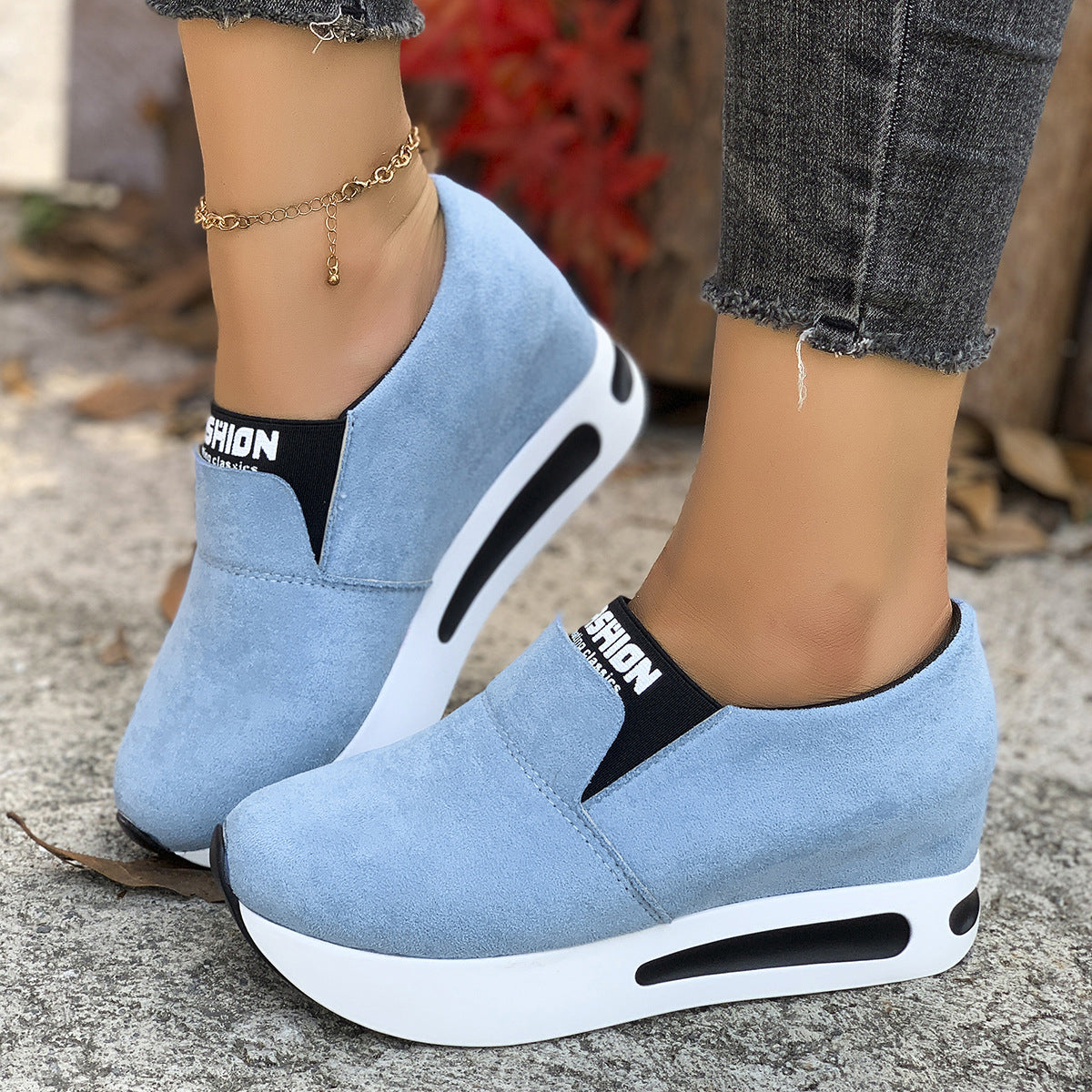Sky blue round toe slip-on sneakers with platform sole and black trim.