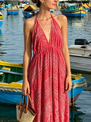 Red paisley print backless maxi dress with halter neck and deep V-neck.