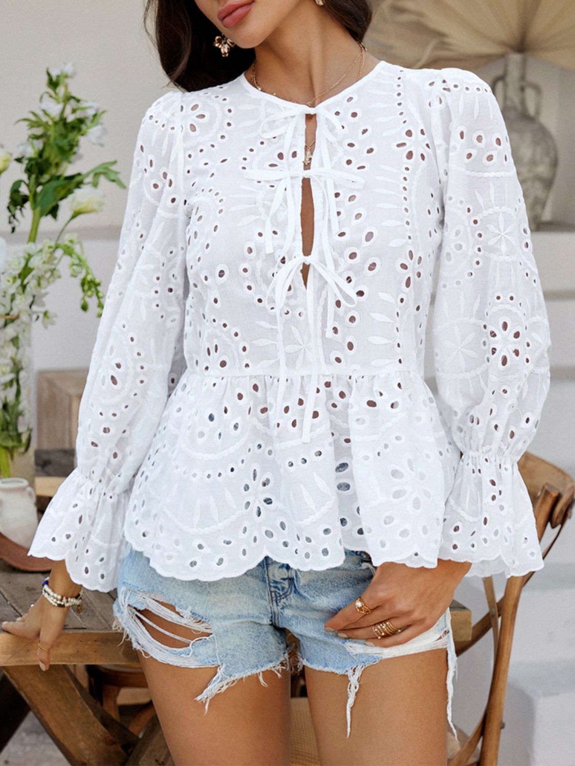 White eyelet embroidered peplum blouse with tie neck and ruffled sleeves