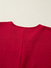 Braided V-neck half sleeve blouse in deep red with textured fabric and a center seam.
