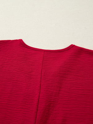 Braided V-neck half sleeve blouse in deep red with textured fabric and a center seam.