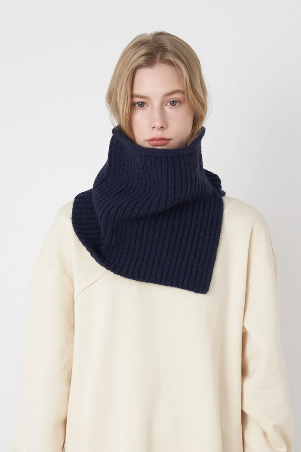 Dark Navy ribbed knit neck warmer with extended panel, worn over a cream sweatshirt.