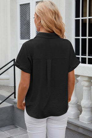 Black textured short sleeve collared shirt with cuffed sleeves and back pleat detail.