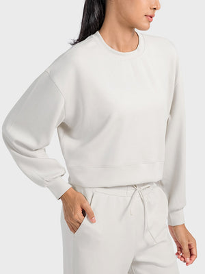 Ivory cropped crewneck sweatshirt with gathered sleeves and ribbed cuffs.