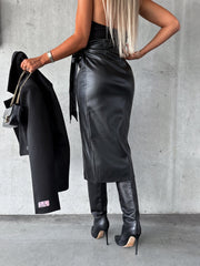 Black faux leather wrap midi skirt with asymmetric hem and tie waist.