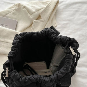 Black quilted drawstring carryall bag with interior details and silver hardware.