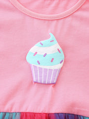 Pink cotton baby dress with cupcake graphic and ruffled tulle hem.