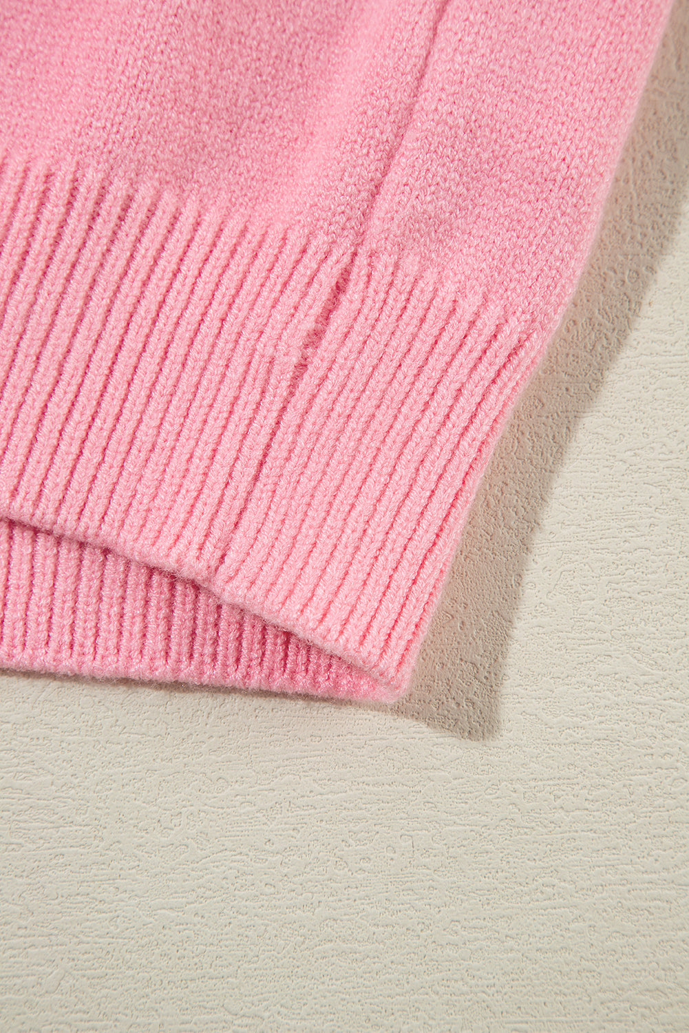 Blush pink knit sweater with ribbed cuffs and hem detail.