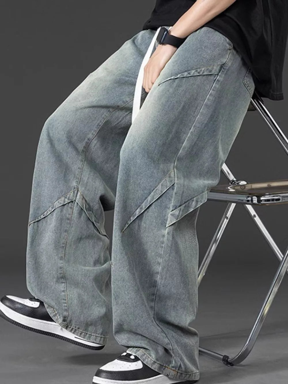 Men's oversized blue denim jeans with adjustable fit and unique paneling detail.