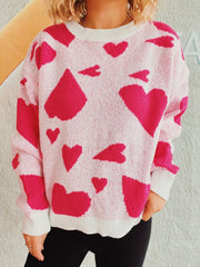 Heart motif knit sweater in hot pink and white acrylic with crewneck.