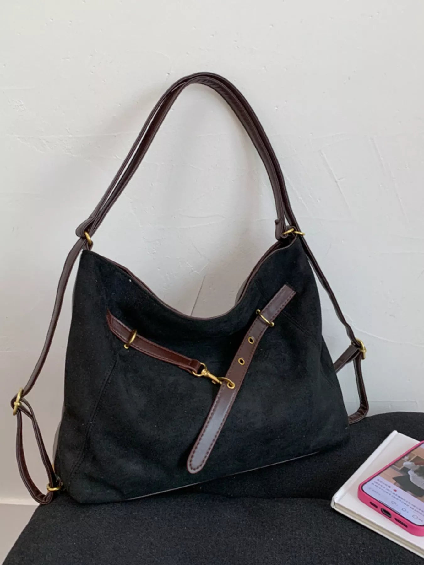 Black suede hobo bag with adjustable strap and dark brown leather trim.