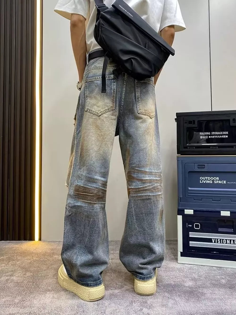 Heavily distressed vintage wide-leg jeans in blue denim with brown wash details.