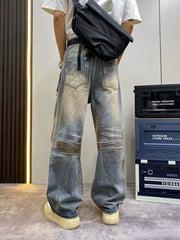 Heavily distressed vintage wide-leg jeans in blue denim with brown wash details.