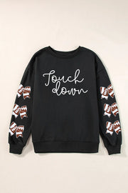 Black sweatshirt with white script "Touch down" and football-themed bow embellishments on sleeves.