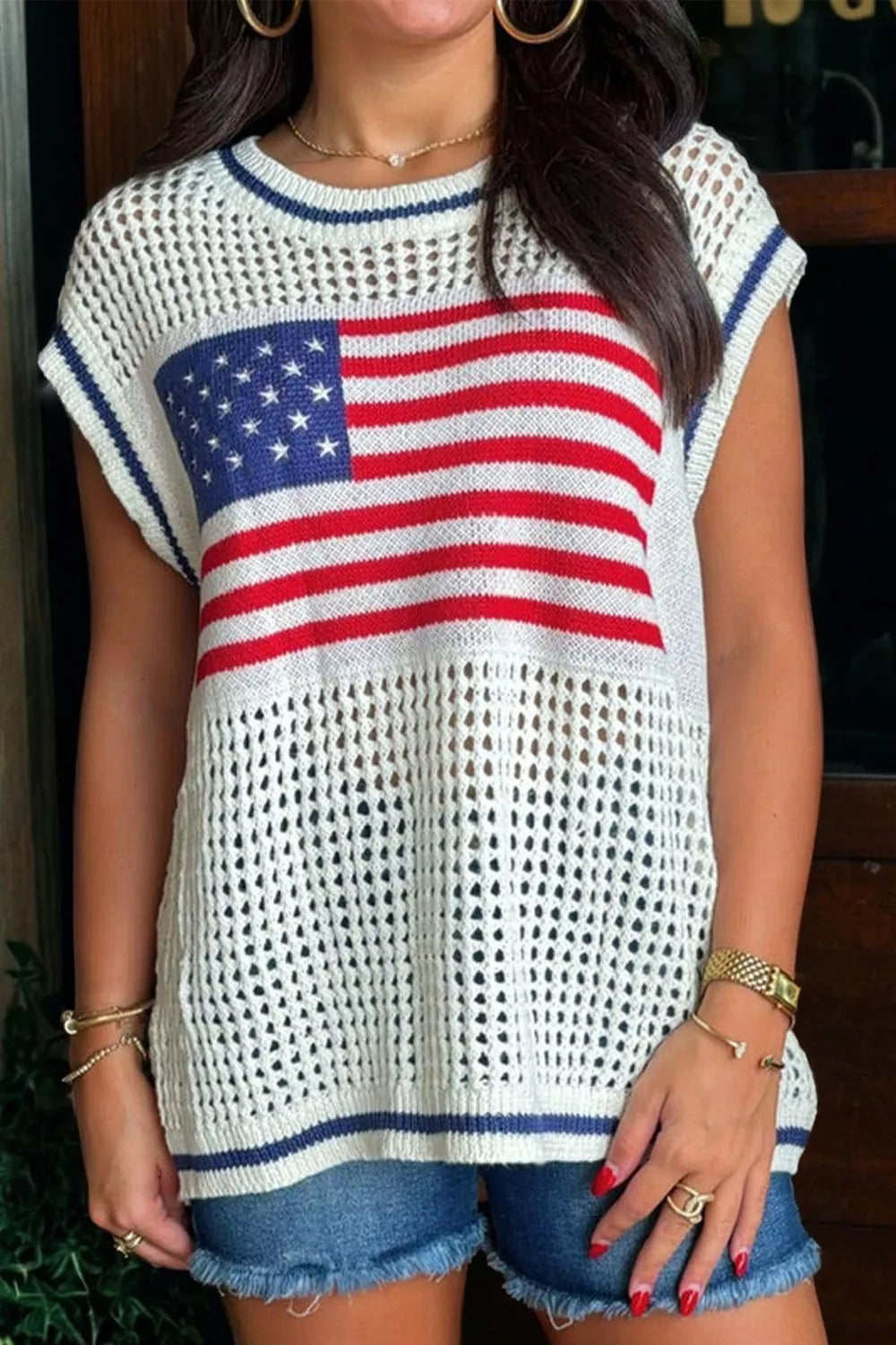 Patriotic eyelet knit sweater with cap sleeves and American flag detail.
