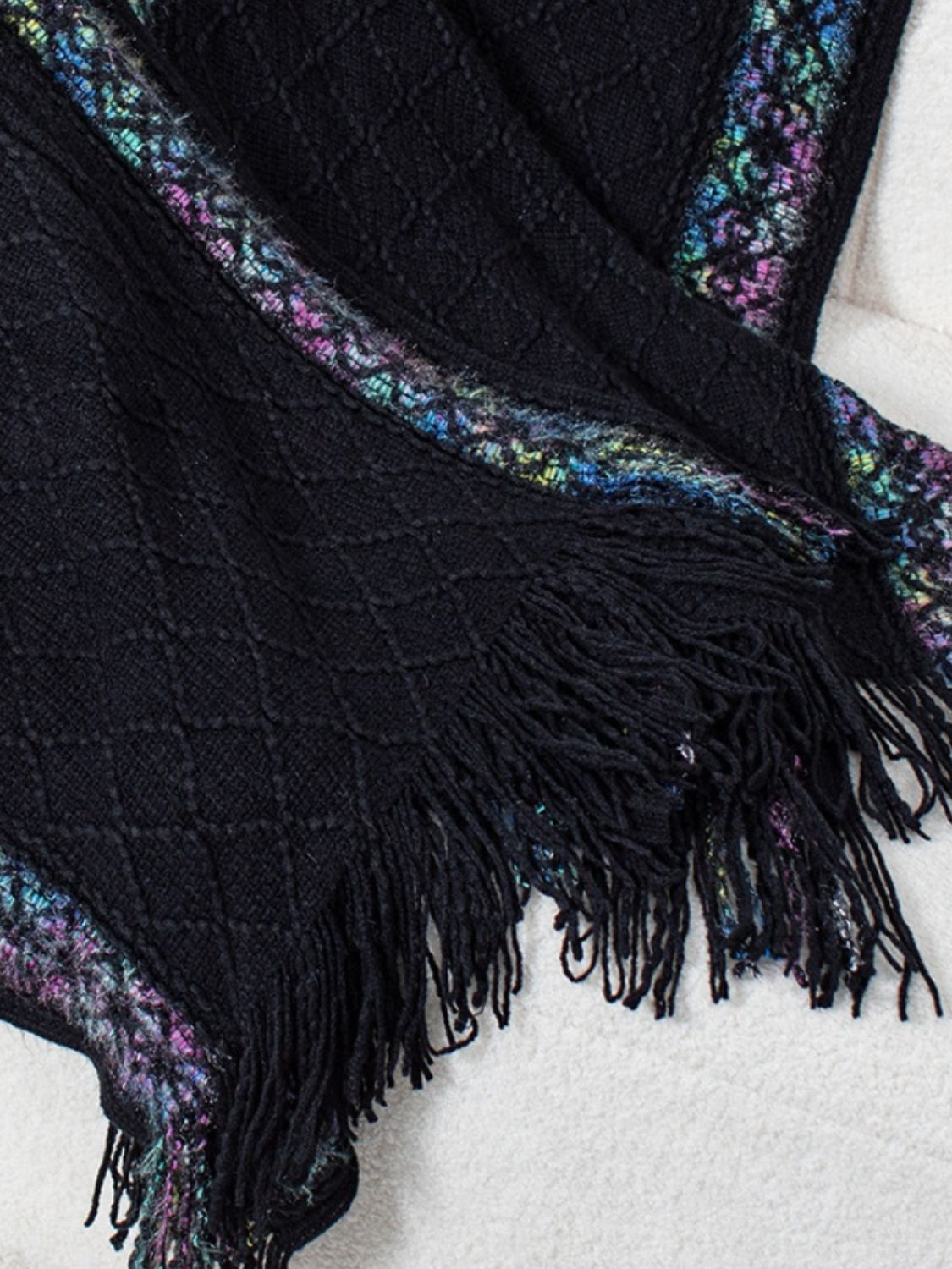 Black knit hooded wrap with diamond pattern, embroidered trim, and fringe detail.