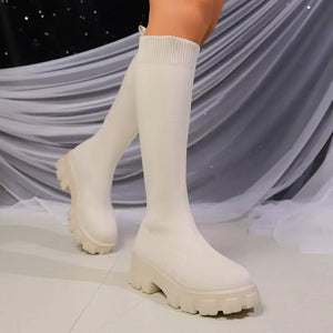 Off-white knit knee-high boots with chunky platform soles and ribbed cuffs.