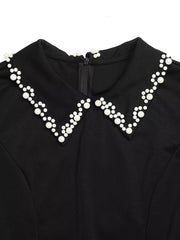Black A-line mini dress with a peter pan collar embellished with white beads.
