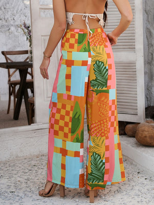 Geometric print wide-leg drawstring trousers in multicolor with tropical leaf and block patterns.
