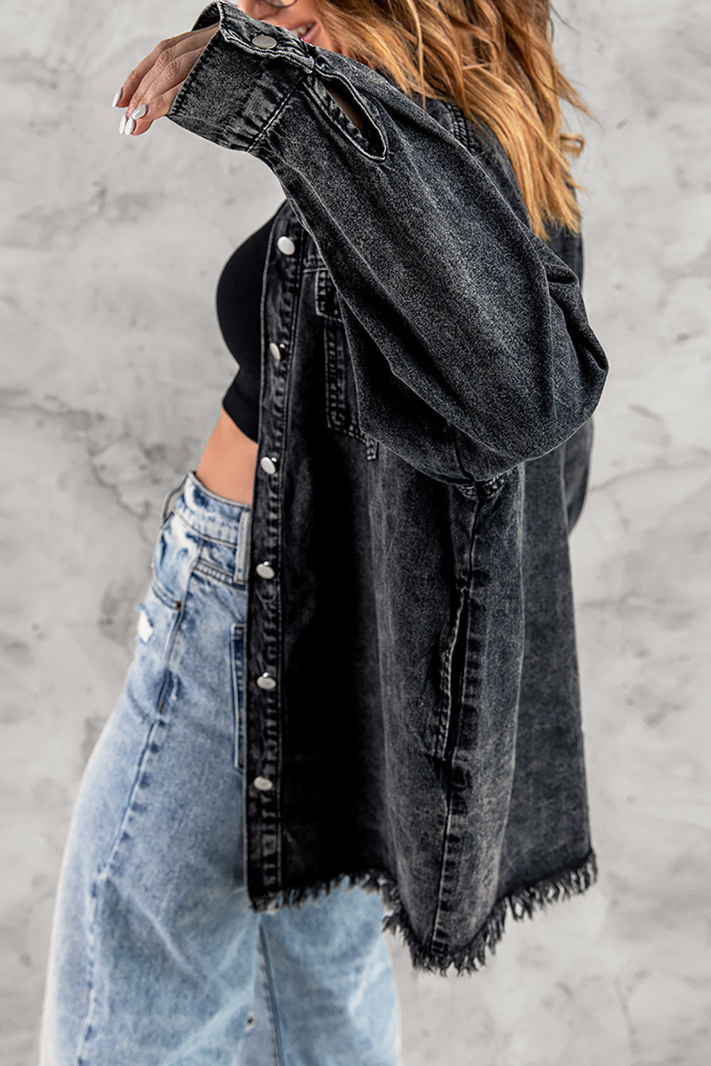 Black oversized denim shirt jacket with frayed hem and button front.