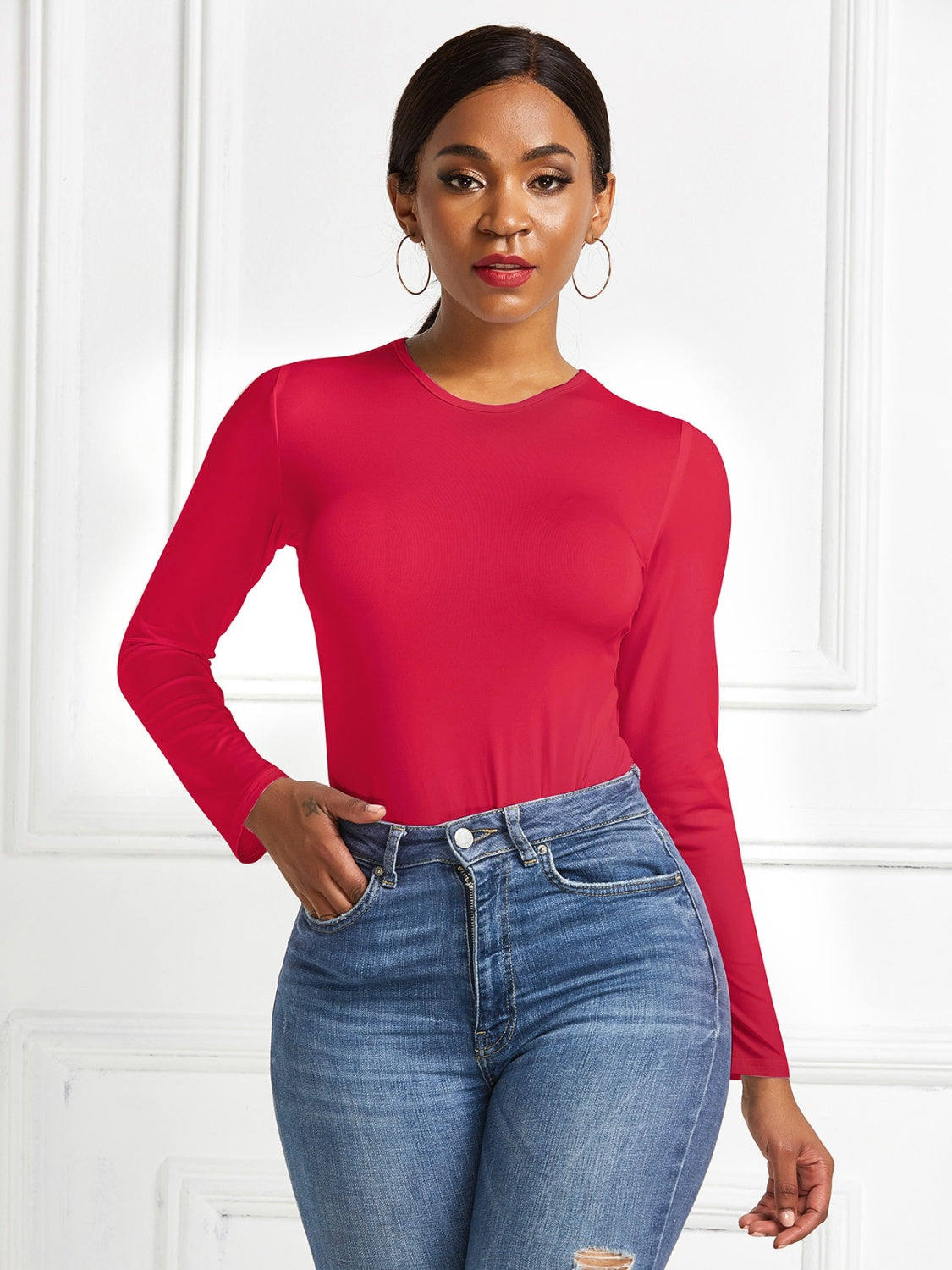 Red long sleeve ribbed bodysuit with crew neck, styled with blue jeans.