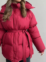Burgundy puffer trench coat with hood and belted waist, shown on a woman.